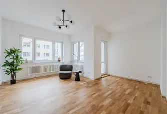 Wohnzimmer mit Parkettboden und Balkontür